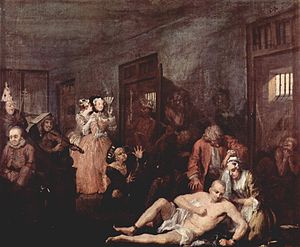 An 1735 oil version of the last scene from William Hogarth's A Rake's Progress, the story of a rich merchant's son, Tom Rakewell whose immoral living causes him to end up in Bethlem. A shaven-head and near-naked Rakewell is depicted in one of galleries of Bethlem. He sits on the floor while his right leg is being manacled by an attendant. A wigged doctor is standing over him. Rakewell's spurned fiancé kneels beside him, crying. Inmates exhibiting various stereotypical forms of madness are shown in their open cells and in the corridor. Two fashionably dressed lady-visitors standing by the cell of a "urinating mad monarch", are clearly amused by the show. One holds a fan up to her face and is clearly smiling while her companion whispers in ear. Hogarth became a governor of Bethlem in 1752.