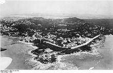 View of a coastal city from a high-altitude point at sea