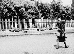 Pedestrians walking past bodies of starved peasants on a street in Kharkiv, 1933.