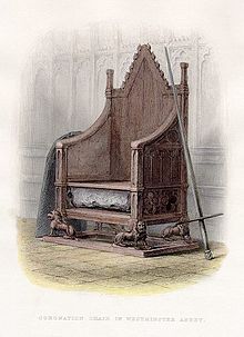 A wooden throne resting on four carved lions. A compartment under the seat holds a large rock. On the right a sword leans up against the chair, on the left a great slab.
