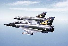 Two camouflaged military jet aircraft flying in formation
