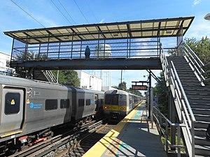 Carle Place LIRR Station; Two trains and the Pedestrian Bridge.jpg