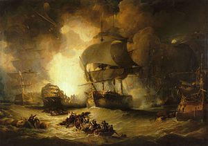 On a choppy sea, a large warship suffers a massive internal explosion. The central ship is flanked by two other largely undamaged ships. In the foreground two small boats full of men row between floating wreckage to which men are clinging.