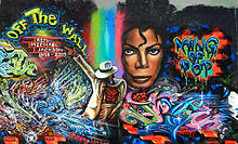 A wall with colorful graffiti depicting Michael Jackson; once his full body dancing, then a close-up of his face.