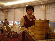A server pushes a cart laden with bamboo baskets
