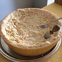 Half a wheel of Parmigiano-Reggiano cheese served on a table.