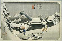 A village in a mountainous landscape. A man with a conical hat and a cane, and a saddled horse can be seen in the foreground. Japanese characters are seen in the down left and top central parts of the image.