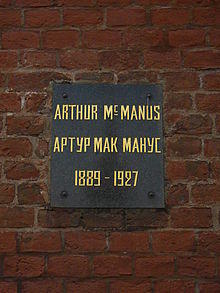 Plaque on a brick wall with inscription: Arthur MacManus/Артур Макманус, 1889–1927