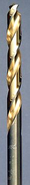 A steel colored twist drill bit with the spiral groove colored in a golden shade.