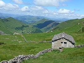 Cabaña pasiega en el puerto de las Estacas de Trueba con el valle del Pas al fondo.jpg