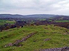 View from Dolebury Warren Hill Fort with remnants of stonework in the foreground. Crook Peak is shown in the background