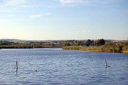 A lake with houses beyond