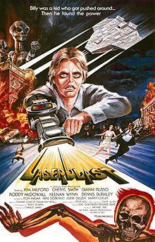 A film poster with a young man with a laser gun extended from his arm, shooting out the title "Laserblast". A tagline at the top reads "Billy was a kid who got pushed around ... Then he found the power". The top left shows two extraterrestrial aliens on top of a burning building, opposite an extraterrestrial spacecraft. Below the burning building, people are seen running away on the street. Credits for the film appear below the title, and a skeleton on fire is at the bottom of the image.