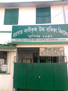 Green-and-white building with signs