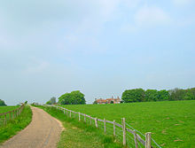 country land, green fields with old house in the background