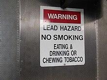 Warning sign posted inside an indoor firing range to alert shooters and instructors about potential for lead posining
