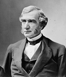 Morrill seated in a suit