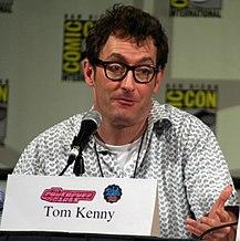 Tom Kenny seated at a microphone looking off to his left