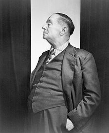 Black and white photograph of H. G. Wells standing and wearing a suit