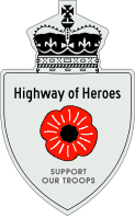 A Highway of Heroes reassurance marker with a red poppy flower in place of a number. Above that is the text Highway of Heroes, and below it SUPPORT OUR TROOPS.
