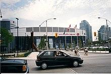 The intersection of a roadway, with a large multi-sport arena in the background