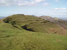 Photo of the British Camp hill showing its terraced Iron Age earthworks