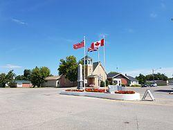Flags and the war cenotaph in Cartwright with the Cartwright United Church in the background.