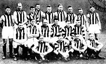 A group of men wearing sleeveless guernseys with black-and-white vertical stripes.