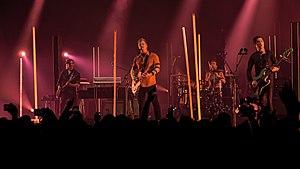 Queens of the Stone Age performing at Wembley Arena in November 2017; left to right: Dean Fertita, Josh Homme, Jon Theodore, and Michael Shuman