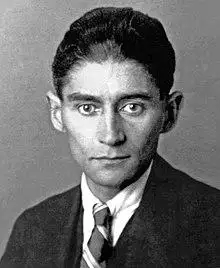 Black-and-white photograph of Kafka as a young man with dark hair in a formal suit