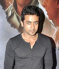 Suriya in a dark, long-sleeved shirt posing for the camera