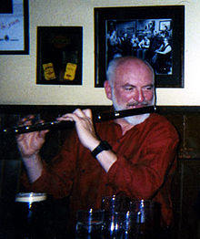 Matt Molloy playing in a session at his pub in March 2000
