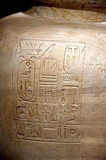 Large round vase of light brown stone inscribed with hieroglyphs