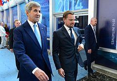 A photograph of John Kerry (left) and Leonardo DiCaprio both dressed in suits and looking away from the camera