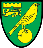 Badge of Norwich City: a green shield with yellow emblems. A bird (canary) on top of a ball as the main image, and a castle above a lion passant guardant in the top left quarter.