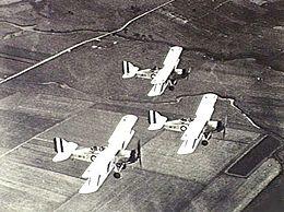 Overhead shot of three military biplanes in flight