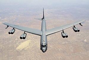 Aerial top/side view of gray B-52H flying over Texas