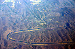 Oblique air photo of the meandering Potomac River at Little Orleans (center), facing north. The photo shows Allegany County, Maryland (left), Morgan County, West Virginia (right), Sideling Hill (right), and the Chesapeake and Ohio Canal.