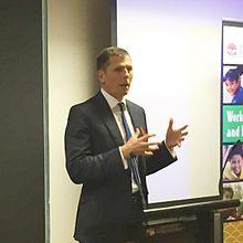 Michael Coutts-Trotter speaking at an event.jpg