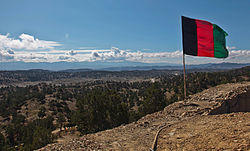 The Afghan national flag overlooks a valley from an observation post at Paktika province in Afghanistan