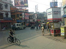 Street with a variety of vehicles: bicycles, a car and a motorcycle