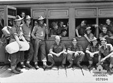 Soldiers milling around a stationary train, ready to entrain