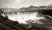 Front view of a dam releasing water through its spillways