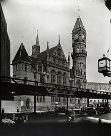 An elevated railroad partly covers the facade of an ornate building