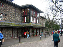 Modern stone-faced theatre with a lake in the background