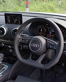 An interior photo of a 2020 Audi A3 Sportback e-tron, showing the digital instrument panel called "Virtual Cockpit" and black leather seats.