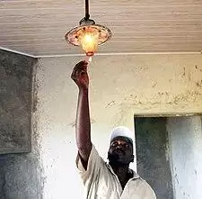 Kenyan dairy farmer lighting biogas lamp