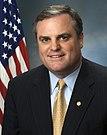 Mark Pryor, head and shoulders photo portrait with flag, 2006.jpg