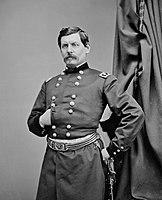 Man with mustache and military uniform, striking a Napoleon pose