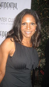 Audra McDonald in a black dress against a white background